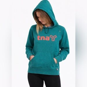 Teal TNA pullover hoodie featuring a pink logo - small
